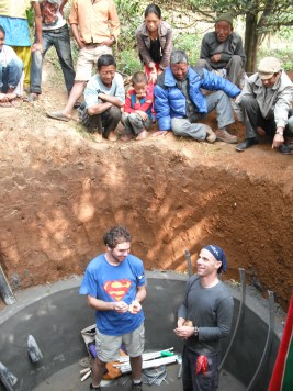 Talesnick (right) and a student in the biogas generator pit with Namsaling villagers looking on